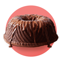 Un bizcocho de chocolate cubierto de chocolate derretido contra un círculo degradado de color salmón.