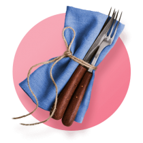 Wood handled silverware wrapped in twine and a blue cloth napkin against a light pink gradient circle.