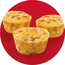 Three mini ham and spinach quiche in front of a red circle.