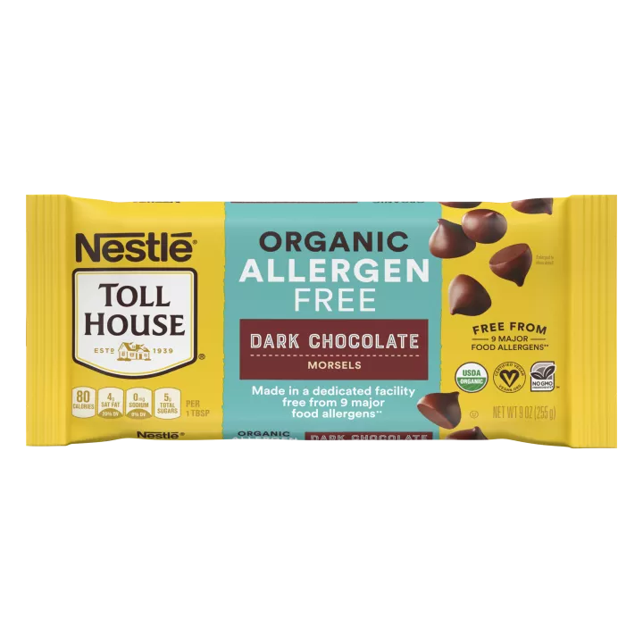 A package of allergen free dark chocolate morsels with a brown label beside a melty chocolate chip cookie.